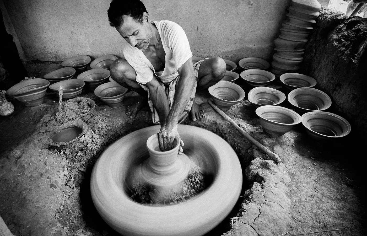 A potter throwing clay in a village workshop