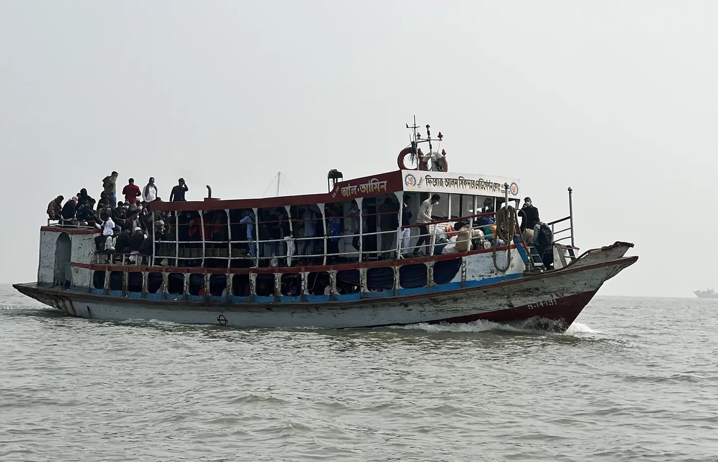 A crowded launch on a wide river