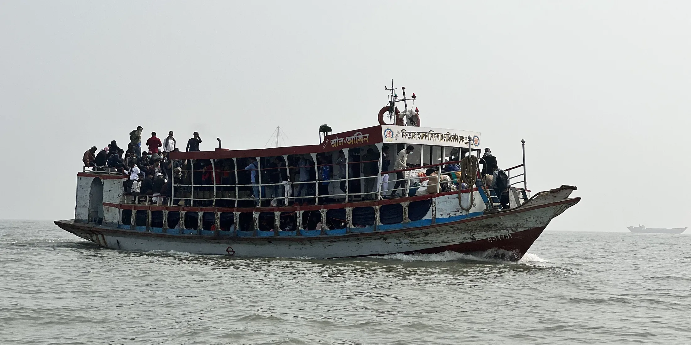 A crowded passenger launch on a wide river